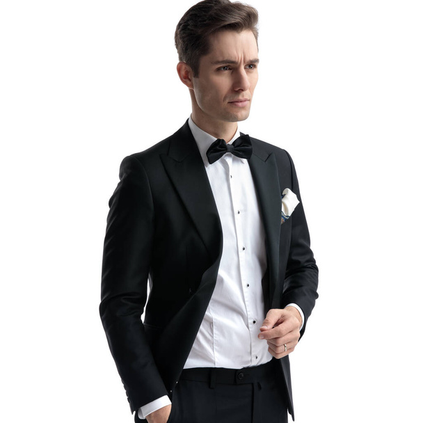 thoughtful young man in tuxedo looking to side - Photo, Image
