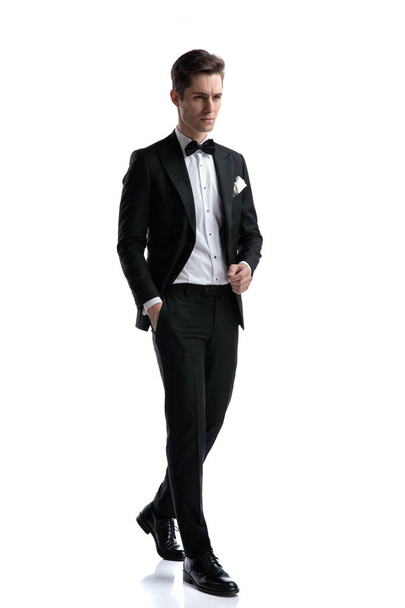 elegant fashion man wearing tuxedo and looking to side - 写真・画像
