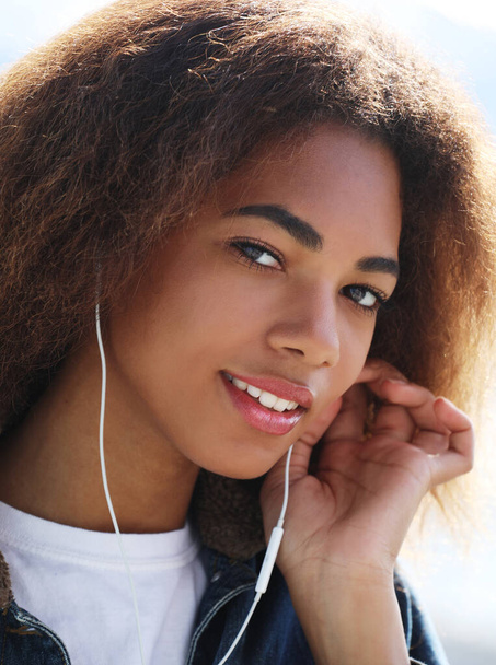 lifestyle concept: Young african american girl using mobile phone and headphones, smiling, - Fotoğraf, Görsel