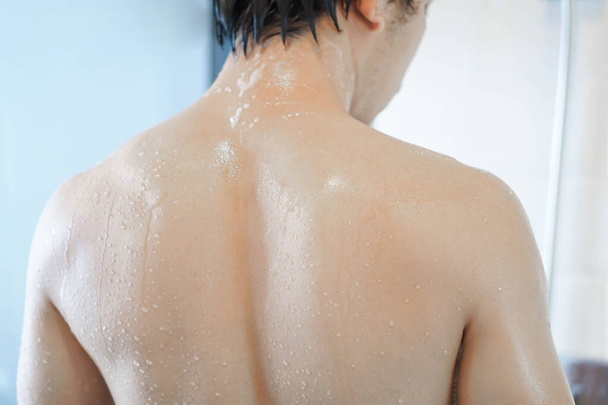 Closeup pohledný asijský muž se sprchou v koupelně, selektivní zaměření - Fotografie, Obrázek