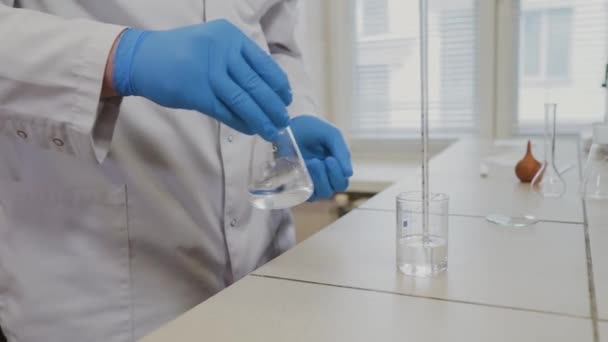 Male scientist with test tubes in a laboratory conducts an experiment. - Video