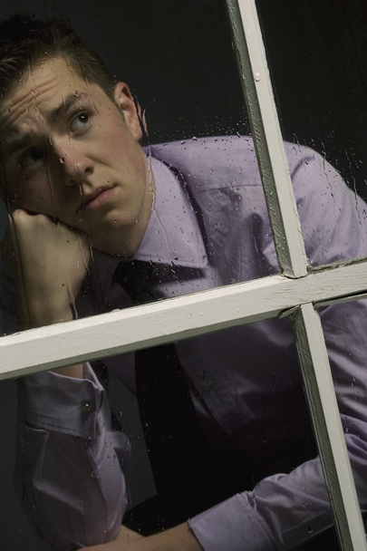 Unhappy Man Looking Out A Window - Фото, зображення