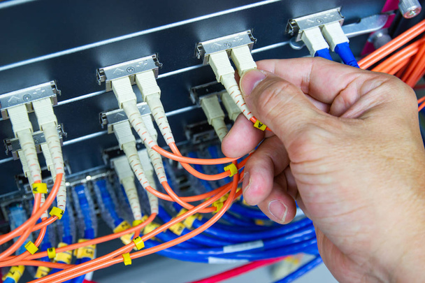Técnico conecte a rede de cabos de fibra para alternar a porta no servidor
  - Foto, Imagem