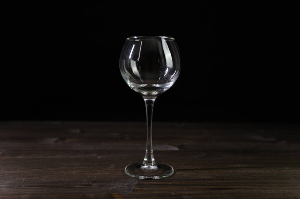 Photo of an empty wine glass. Nice color on a black background. - Fotó, kép