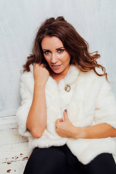 retrato de una hermosa mujer de moda con rizos en un abrigo de piel blanca
 - Foto, imagen
