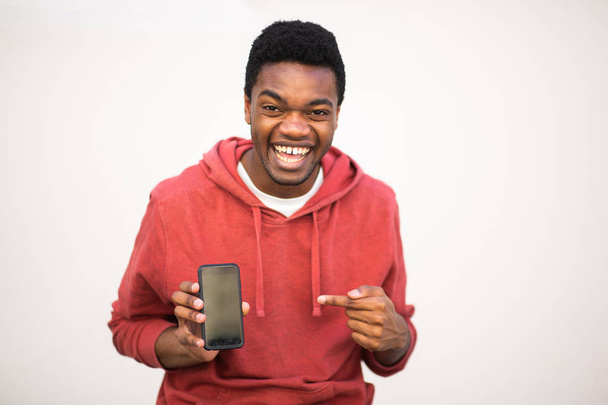 Ritratto felice uomo afro-americano che tiene il cellulare e indica lo schermo
 - Foto, immagini