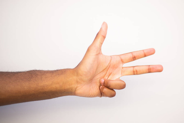 Close up african american man arm with three fingers pointing against white background - Photo, Image