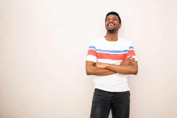 Портрет молодого афроамериканського чоловіка, який сміється з руки, схрещений білим фоном. - Фото, зображення
