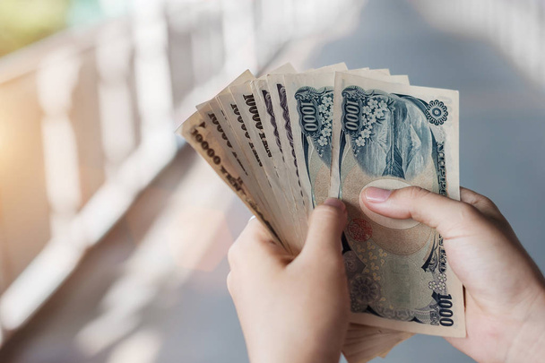 Main d'homme d'affaires tenant la pile de billets en yens japonais. affaires
,  - Photo, image