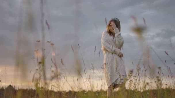 Graceful lady spacery w wiejskim trawiastym polu - Materiał filmowy, wideo