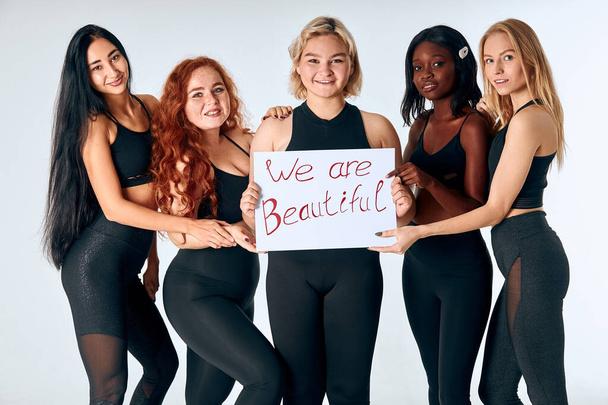 Beautiful girls holding poster isolated over white background - Φωτογραφία, εικόνα