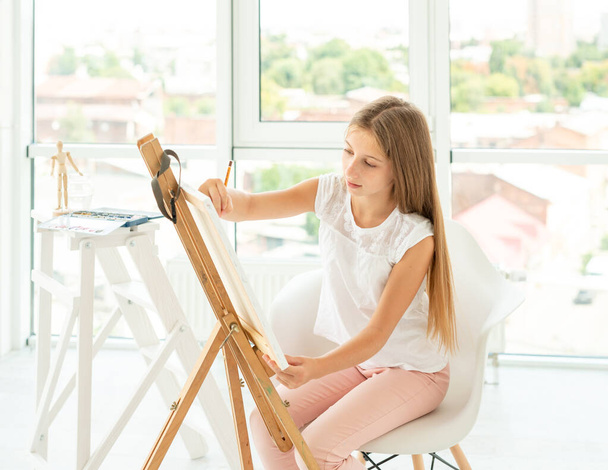 teenager girl makes pencil sketch on canvas - 写真・画像