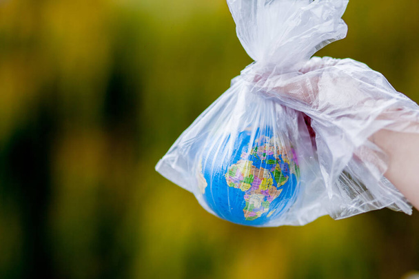 The human hand holds the planet earth in a plastic bag. The conc - Foto, Imagem