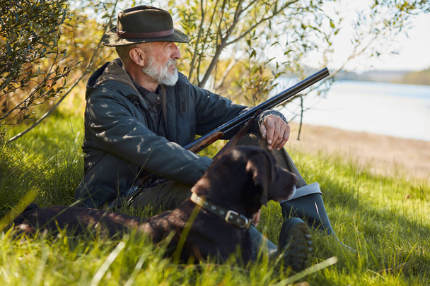 Senior hunter resting with dog, sit on grass - Fotografie, Obrázek
