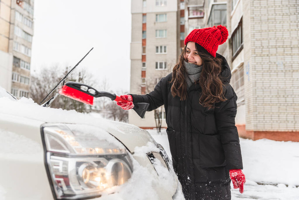 雪の後にブラシできれいな車を女性 - 写真・画像