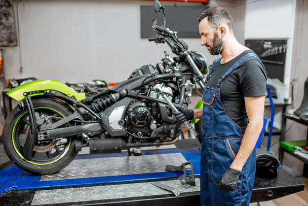 Mechaniker repariert Motorrad in der Werkstatt - Foto, Bild