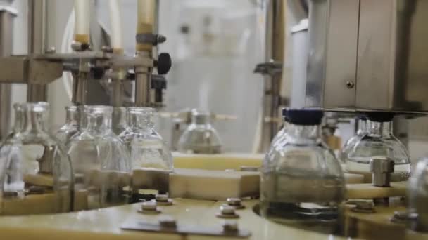 Geneesmiddelen op een assemblagelijn gieten in glazen flessen voor injectie. - Video