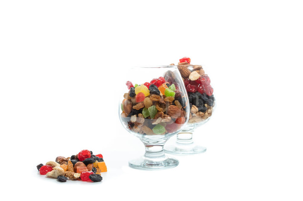 Two glasses with a variety of nuts and dried fruits. Colorful berries. A variety of nuts. - Photo, Image