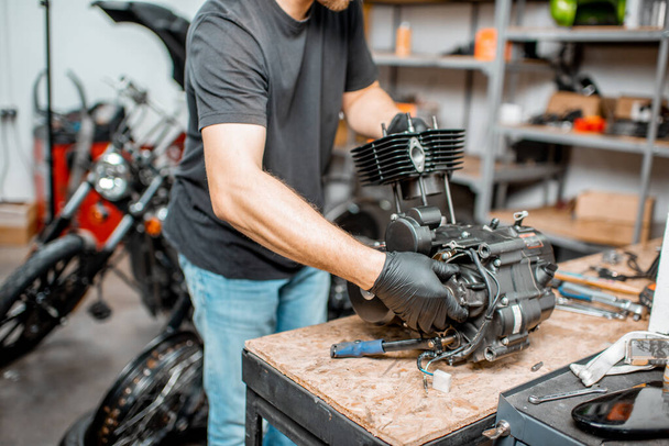 オートバイのエンジンを修理する男 - 写真・画像