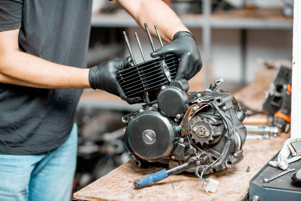 Man repairing motorcycle engine - Foto, Bild