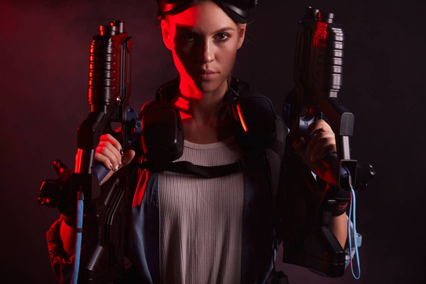 Portrait of confident woman with guns for VR game - Foto, immagini