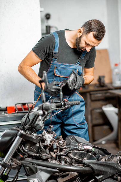 Mechanic repairing or tuning motorcycle - Photo, Image