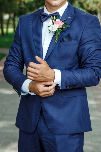 groom dressed in an elegant suit posing on a street background. - Фото, изображение