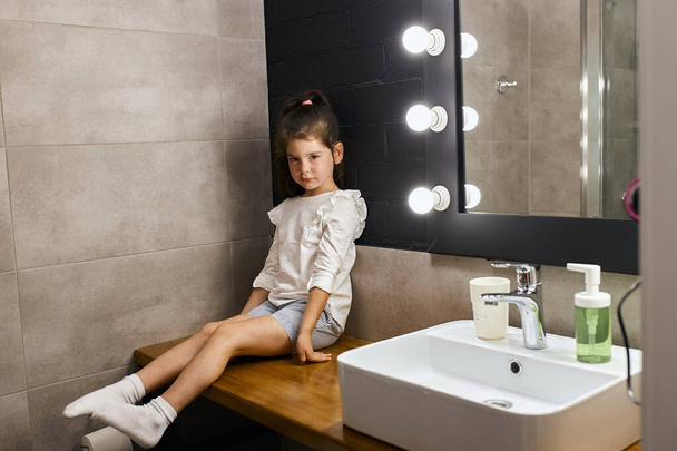 Charming kid sitting in bathroom - Foto, afbeelding