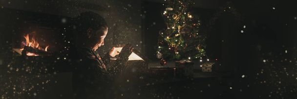 Muchacho joven excitado abriendo regalo de Navidad
 - Foto, imagen