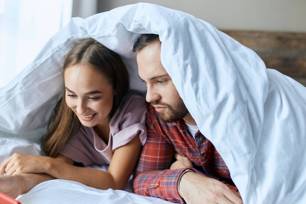 Happy loving couple under white blanket - Фото, зображення