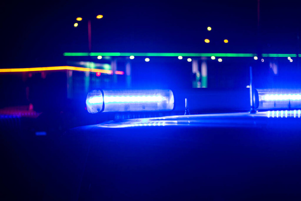 νύχτα. μπλε αυτοκίνητο της αστυνομίας με επιλεκτική εστίαση και θολούρα bokeh. - Φωτογραφία, εικόνα