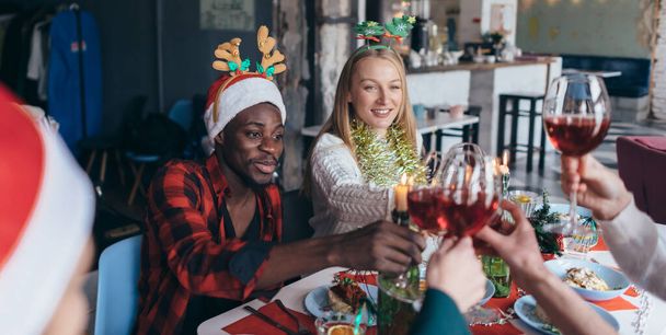 Люди, які святкують Різдво або Новий рік, клінкерні окуляри сидять за столом
. - Фото, зображення