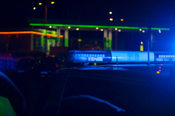 нічний час. синій поліцейський автомобіль з вибірковим фокусом і розмитим боке
. - Фото, зображення