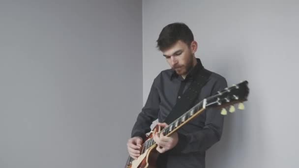 Male with beard playing on solo electric guitar isolated. Hands playing on electric guitar practicing for rock and roll concert. - Felvétel, videó
