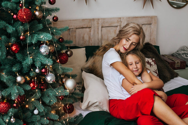 Portrait of mom and daughter in anticipation of Christmas - Foto, imagen