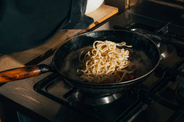 frying spaghetti in a pan - Foto, imagen