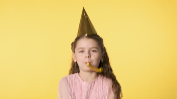 Excited girl throwing golden confetti into air. Concept of holiday and party. Happy little girl in pink dress throwing confetti at yellow background. Slow motion. 4k, UHD 60 FPS - Filmmaterial, Video