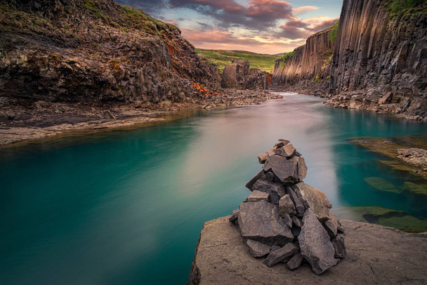 montículo de piedra en las orillas del río. Cañón Studlagil
 - Foto, Imagen
