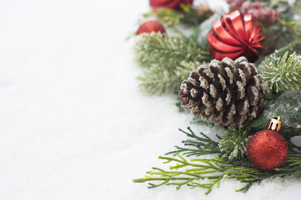 Різдвяний фон з кульками, вафлями і зеленими ялиновими гілками, сосновими шишками, на білому сніговому тлі. Зимові свята. Різдвяна абстрактна листівка. Копіювати простір
. - Фото, зображення