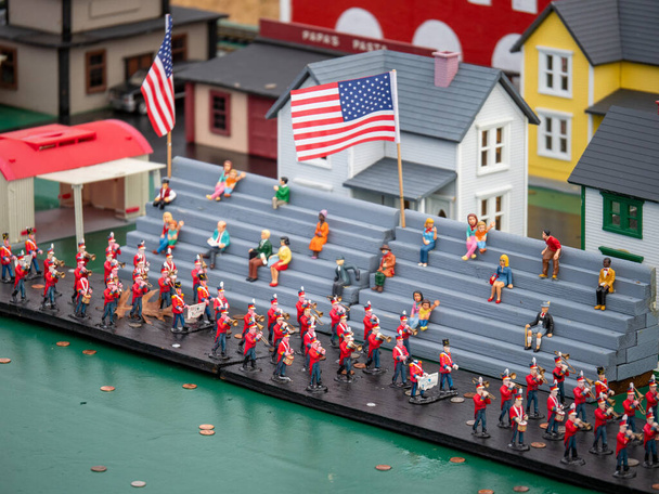Miniature figurines marching band in parade with on lookers with US flag - Photo, Image