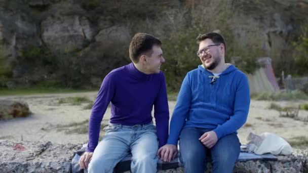 Δύο γκέι κάθονται στη θάλασσα. - Πλάνα, βίντεο