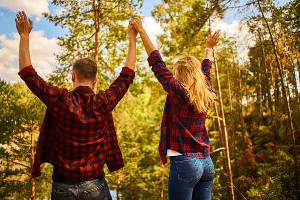 Couple raised up hands and relax at forest together. Happy to spend time together.  - Fotografie, Obrázek