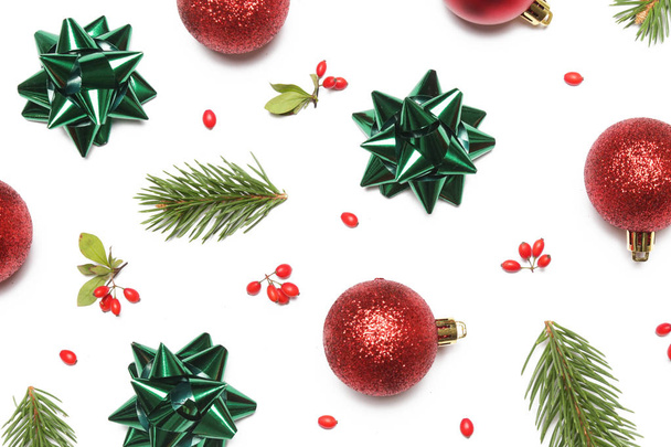 Festive winter background. Red Christmas ornaments and green bows isolated on white background. Christmas, winter holiday, new year concept. - Foto, Imagen