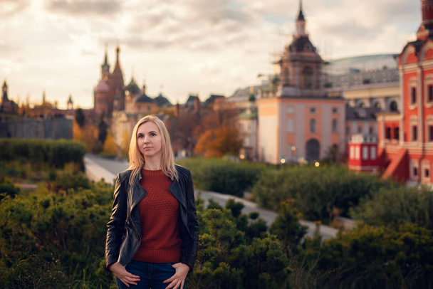 portrait of a young beautiful blonde in a hat on a background of the city of Moscow - Foto, Imagen