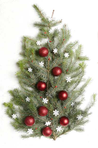 Červené vánoční ozdoby uspořádány na malém vánočním stromečku izolované na bílém pozadí - Fotografie, Obrázek