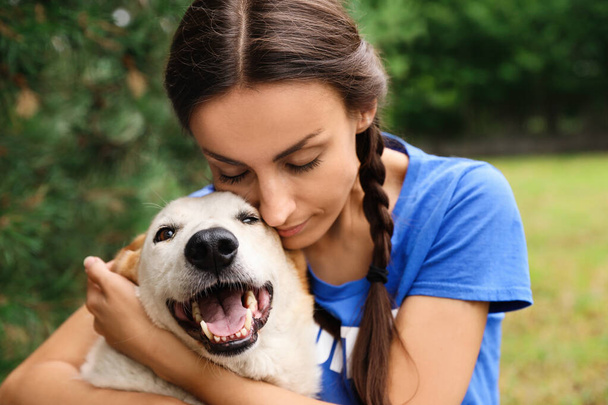 Hayvan barınağında evsiz köpekle birlikte gönüllü bir kadın. - Fotoğraf, Görsel