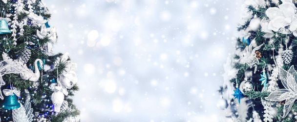 Christbaumhintergrund und Weihnachtsschmuck mit Schnee, verschwommen, funkelnd, leuchtend. Frohes Neues Jahr und Weihnachten Thema. - Foto, Bild