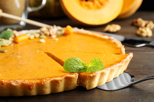 Delicious fresh homemade pumpkin pie on dark wooden table, closeup - Zdjęcie, obraz