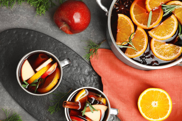 Tasty mulled wine with spices on grey table, flat lay - Fotoğraf, Görsel