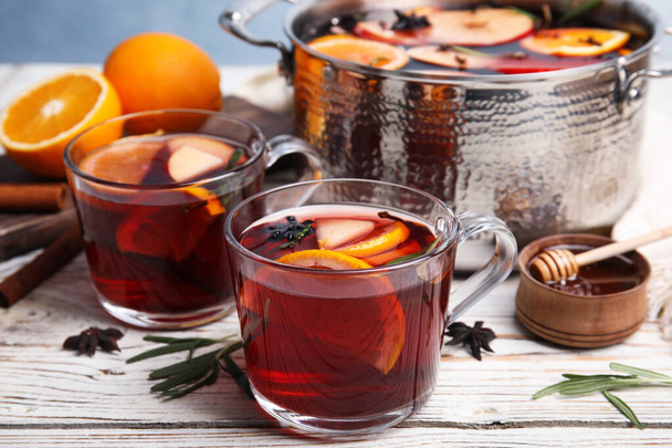 Tasty mulled wine with spices on white wooden table - Foto, imagen